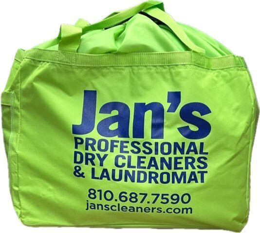 Bright green bag with "Jan's Professional Dry Cleaners & Laundromat" and contact details printed in blue.